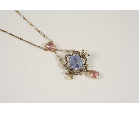 AN EARLY 20TH CENTURY SAPPHIRE, DIAMOND, TOURMALINE AND PEARL SET PENDANT centred with a hexagonal pale blue sapphire within 