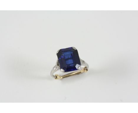 A SYNTHETIC SAPPHIRE AND DIAMOND RING the rectangular-shaped synthetic sapphire is set with three single-cut diamonds to each