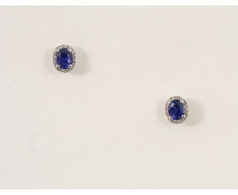 A PAIR OF SAPPHIRE AND DIAMOND CLUSTER STUD EARRINGS each earring set with an oval-shaped sapphire within a surround of small