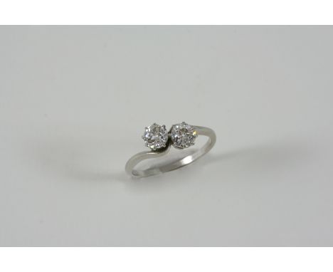 A DIAMOND CROSS-OVER RING set with two old brilliant-cut diamonds weighing approximately 0.80 carats in total. Size O.