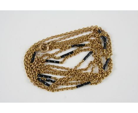 A 15CT. GOLD LONG GUARD CHAIN  mounted with black and white enamel batons, 135cm. long, 26 grams.