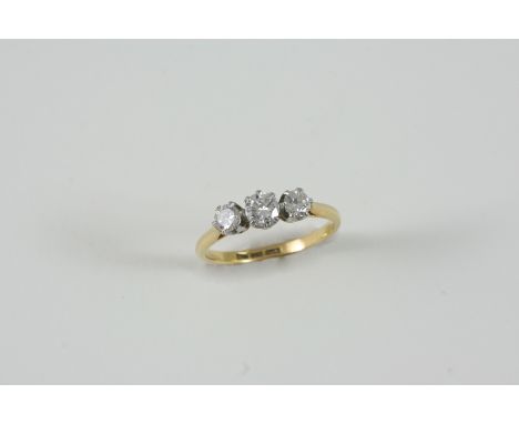 A DIAMOND THREE STONE RING the three graduated old brilliant-cut diamonds are set in gold. Size N.