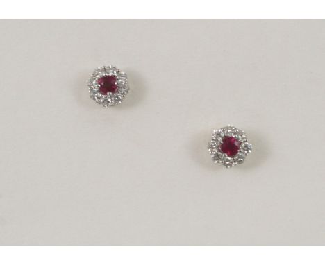 A PAIR OF RUBY AND DIAMOND CLUSTER STUD EARRINGS the circular-cut ruby is set within a surround of circular-cut diamonds, in 