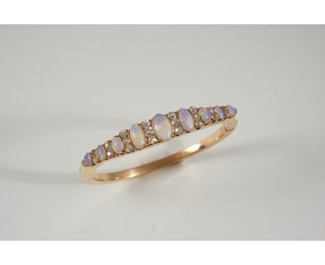 AN OPAL AND DIAMOND HALF HINGED BANGLE set to one side with graduated oval solid white opal cabochons, each divided by old br