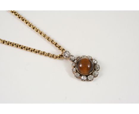 A VICTORIAN TIGER'S EYE AND DIAMOND CLUSTER PENDANT the circular tiger's eye cabochon is set within a surround of cushion-sha
