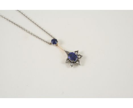 A SAPPHIRE AND DIAMOND PENDANT the flowerhead design is centred with an oval-shaped sapphire within a surround of rose-cut di