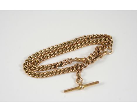 A 9CT. GOLD CURB LINK WATCH CHAIN suspending a 9ct. gold 't' bar, 36cm. long, 15 grams.