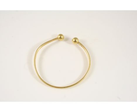 AN 18CT. GOLD BANGLE with ball terminals, 8.3 grams.