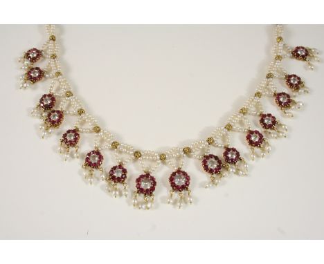 A RUBY AND SEED PEARL NECKLACE the pearl necklace is mounted with sixteen ruby and white stone cluster drops, suspending furt