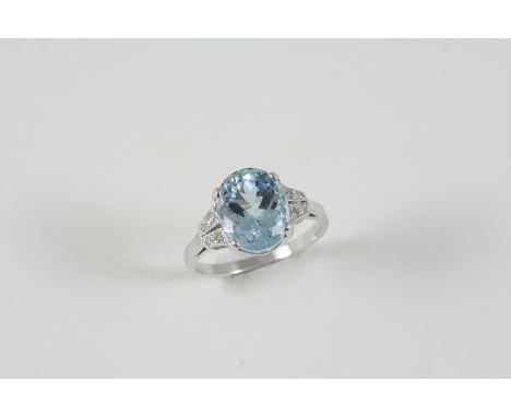 AN AQUAMARINE AND DIAMOND RING the oval-shaped aquamarine is set with four circular-cut diamonds to each shoulder, in 18ct. w