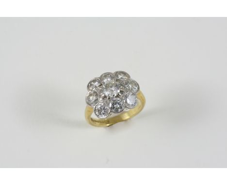 A DIAMOND CLUSTER RING centred with a brilliant-cut diamond within a surround of eight brilliant-cut diamonds and six small d