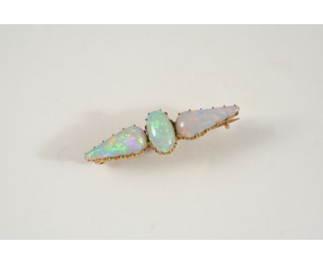 AN OPAL BROOCH set with an oval and two pear-shaped solid white opal cabochons, in gold, 4.5cm. wide.