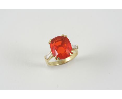 A FIRE OPAL AND DIAMOND RING the oval-shaped fire opal weighs approximately 5.40 carats and is set with a baguette-cut diamon