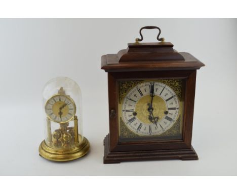 A vintage mantle clock with chiming movement in wooden case. Brass dial with Roman numerals. (with original key) Together wit