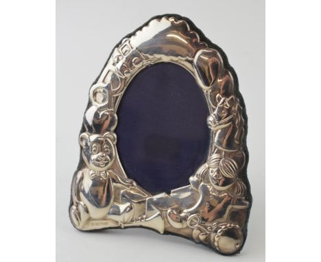 Hallmarked silver photo frame with dolls, teddys and toys decoration, easel back, 13cm tall, Sheffield 1996.