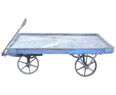 A large blue painted railway luggage trolley, with wooden frame metal cappings and wheels, 57cm high, 185cm wide, 117cm deep.