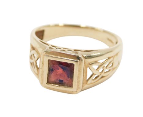 A 9ct gold and garnet set ring, the square cut garnet in a mount with Celtic design pierced shoulders, size U½, 3.7g.