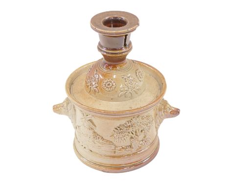 A mid-19thC stoneware tobacco jar and cover, the lid with candle sconce, the base decorated with dog masks, windmill, tavern 