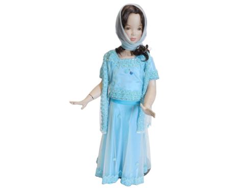 A small child's mannequin, wearing Indian dress, on a metal stand, 113cm high.