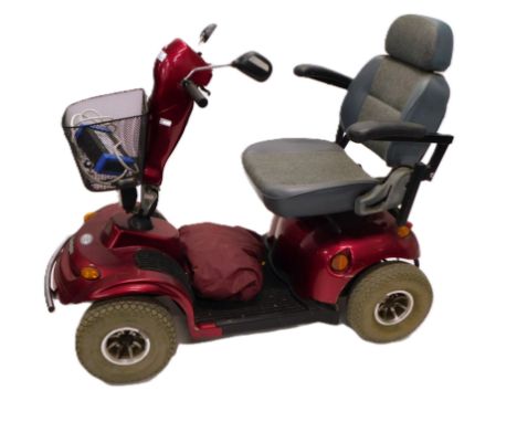 A Kensington electric mobility scooter, in red, with battery charger and key.