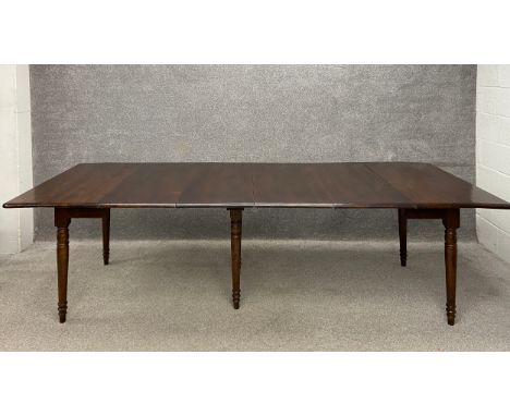 A 19th century mahogany extending concertina dining table having a rectangular top raised on six turned tapering supports on 