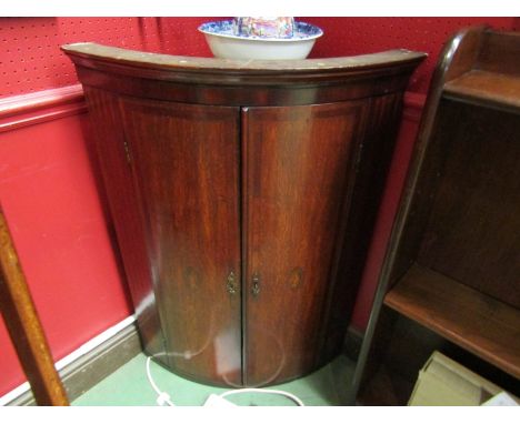 A George III North country oak bow front corner cupboard Circa 1800 the two doors with crossbanding and inlaid conch decorati
