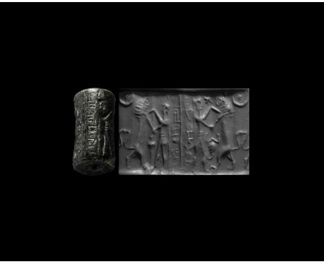 13th-9th century BC. A substantial serpentine cylinder seal with frieze of two combat scenes, each a hero stabbing a rearing 
