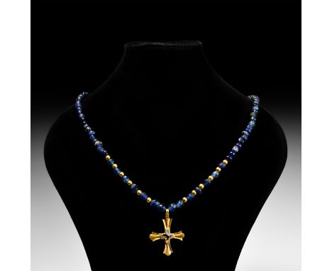 6th-8th century AD. A restrung necklace composed of graduated blue glass beads of mainly oblate form and six later gilt beads