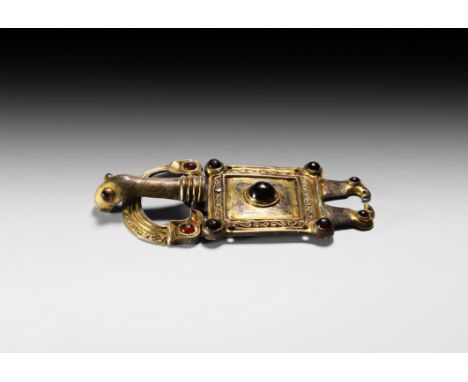 5th-6th century AD. A silver-gilt 'eagle' buckle and plate comprising: a domed D-shaped loop with stepped outer edge and runn