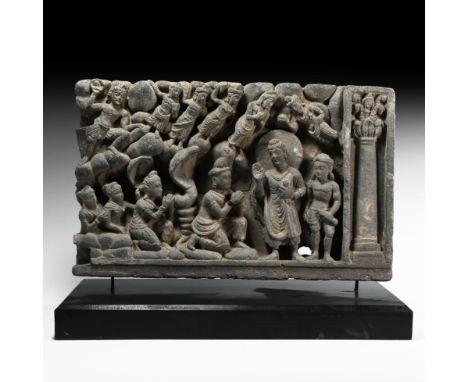 2nd-4th century AD. A carved schist frieze fragment with nimbate Buddha standing with right hand raised flanked by attendants