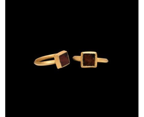6th century AD. A gold finger ring with D-section hoop, square bezel with carinated profile, cell with inset garnet cloison. 