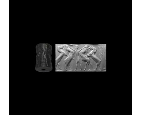 2nd millennium BC. A large black jasper cylinder seal with frieze depicting a hero grasping the horns of two addorsed rearing