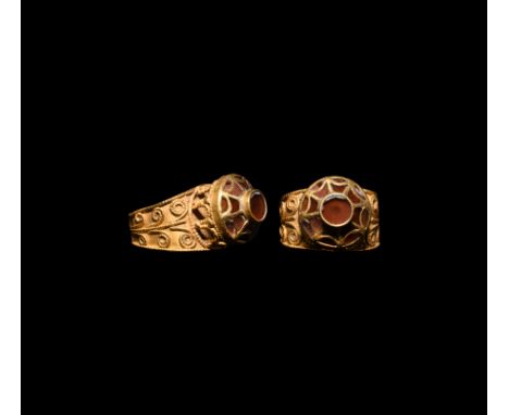 7th century AD. A gold finger ring comprising a broad flat-section hoop with applied beaded wire borders and scrolled tendril