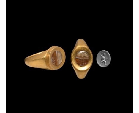 2nd-1st century BC. A substantial gold ring with facetted and angled shoulders, raised bezel with everted rim set with finely