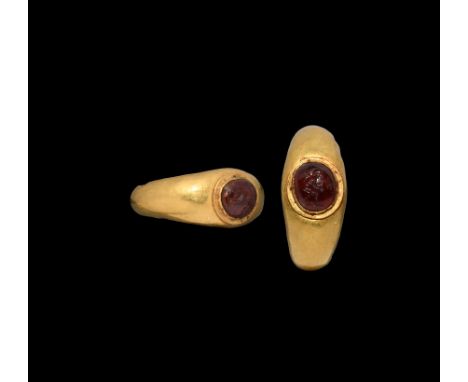 1st century BC-1st century AD. A gold ring with D-section hoop, expanding at the shoulders; oval-shaped setting holding a pol