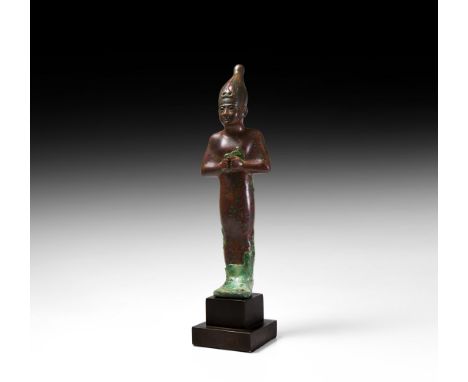 26th-30th Dynasty, 664-343 BC. A bronze statuette of a standing mummiform votive representing the god Osiris; hands emerging 