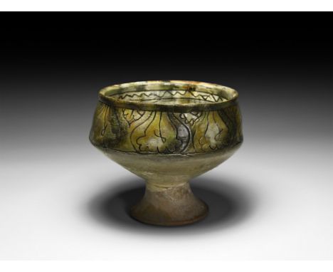 12th-early 13th century AD. A part-glazed ceramic sgraffito bowl with carinated body, slightly everted rim and flared foot; i