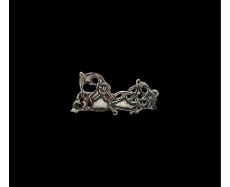 8th-9th century AD. An Oseberg style silver plate brooch in the form of a recumbent gripping beast enmeshed in loops of three