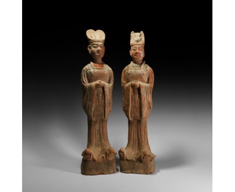 Tang Dynasty, 618-907 AD. A pair of substantial ceramic male figures each standing on an integral base, head straight, arms h