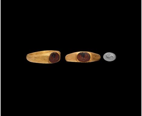 3rd century AD. A gold ring with D-section hoop with expanding facetted shoulders and discoid bezel set with red carnelian in