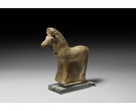 4th-3rd century BC. A hollow-formed ceramic standing horse, head held aloft, long, full tail and cropped mane; phalera disc b