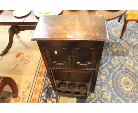 Oak cabinet, the top with pair of cupboard doors with pipe racks, the bottom with rotary door fitted for three bottles.  Heig