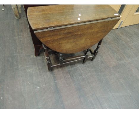 A late 19th/early 20th century oak gate leg dining table in the 17th century style having drop leaf oval top, with drawer, on