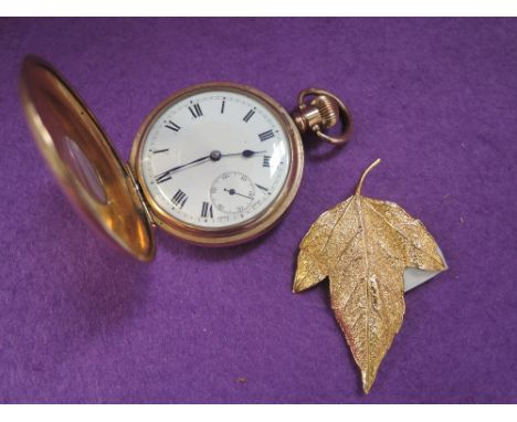 A gold plated half hunter pocket watch having Roman numeral dial with subsidiary seconds in a plain plated case with black en