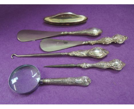 Five HM silver handled dressing & manicure tools including shoe horn, nail buffer, and an HM silver handled small magnifying 