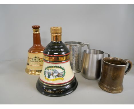 A Bell's whisky decanter, Christmas 1990, sealed and a Bell's blended Scotch whisky decanter, empty, and three mugs