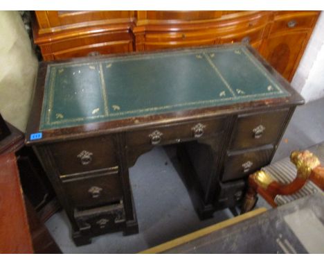 A mid 20th century oak kneehole desk with a green scriber over seven drawers, raised on bracket feet, 30h, 37 w