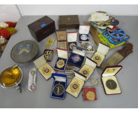 A mixed lot to include archery medals and badges, an Eversure car headlamp, a Victorian tea caddy, a 1938 gold medal award fo