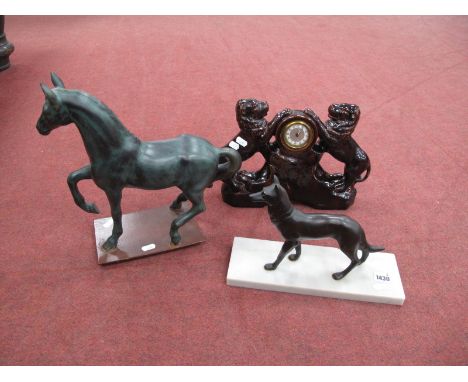 A French Mantle Clock, in treacle glaze case featuring rampant lions, 34cm wide. Dog and horse figures. (3)