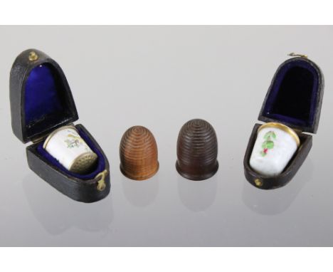 A small collection of four antique thimbles to include two turned wooden examples together with two ceramic examples. 